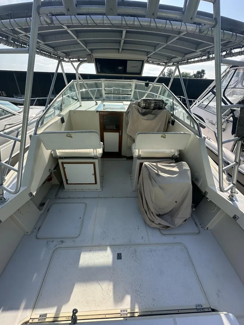 Slide: The Image of 1984 Aquasport 270 Express Fisherman boat interior with covered seating and helm. - 7