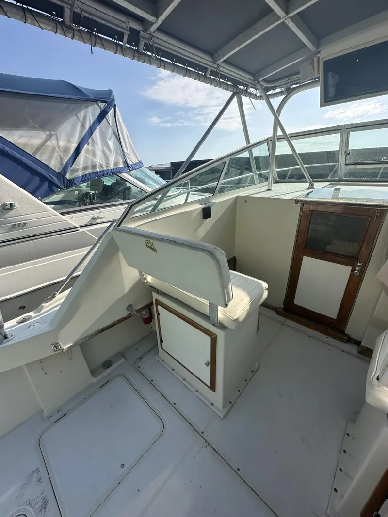 Slide: The Image of 1984 Aquasport 270 Express Fisherman boat cockpit with seating and storage. - 9