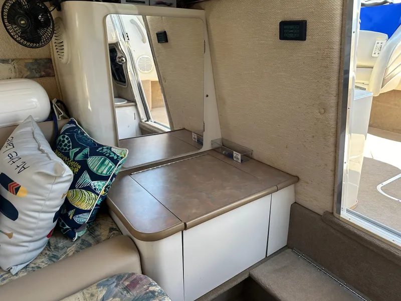 Slide: The Image of 1998 Chaparral 2335 SS cabin interior with seating, pillows, and storage compartments. - 13