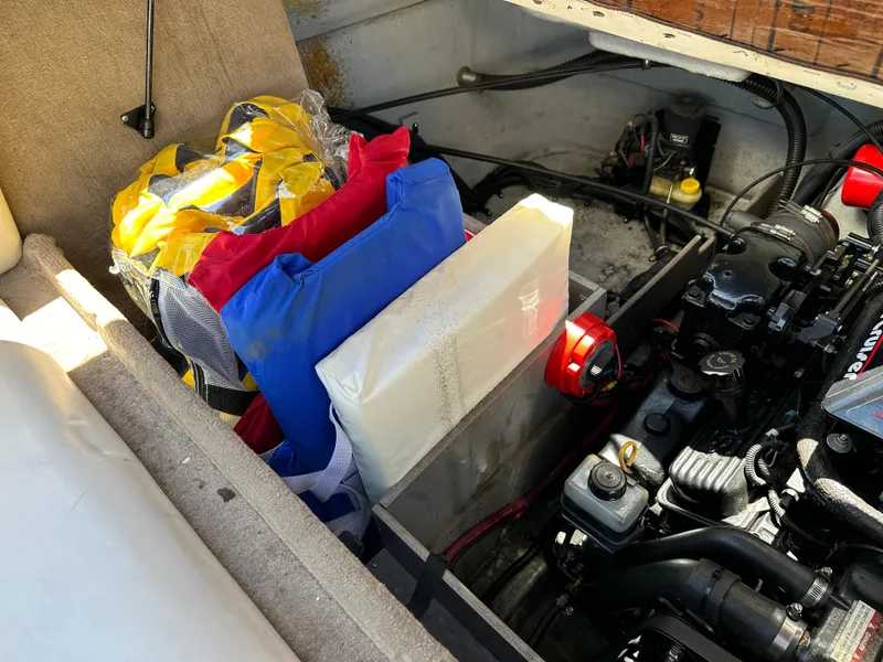 Slide: The Image of 1998 Chaparral 2335 SS boat engine compartment with life jackets and safety equipment. - 15