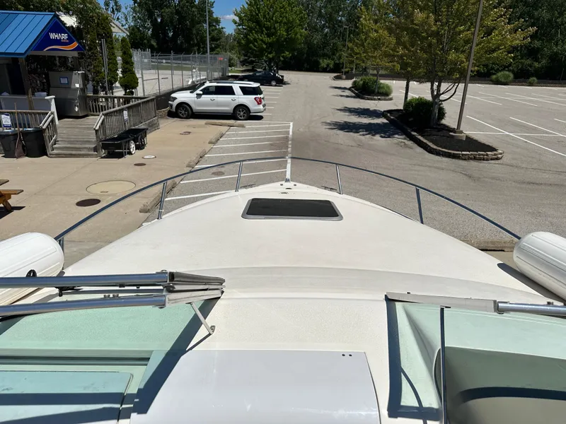 Slide: The Image of 1998 Chaparral 2335 SS boat docked near a parking lot and restaurant. - 8