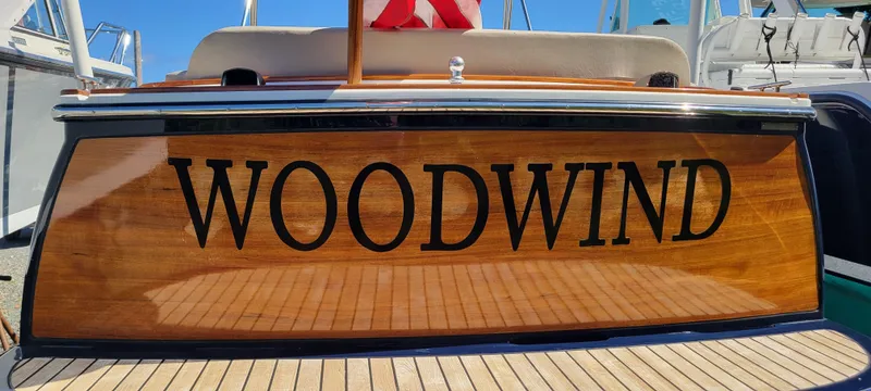 Slide: The Image of 2017 Vanquish Runabout boat named "Woodwind" with polished wood finish. - 11