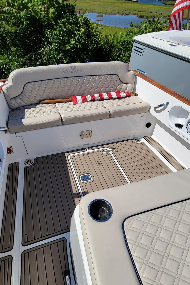 Slide: The Image of 2017 Vanquish Runabout boat interior with cushioned seating and wooden deck. - 12