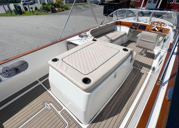 Slide: The Image of 2017 Vanquish Runabout boat interior with beige seating and wooden accents. - 2