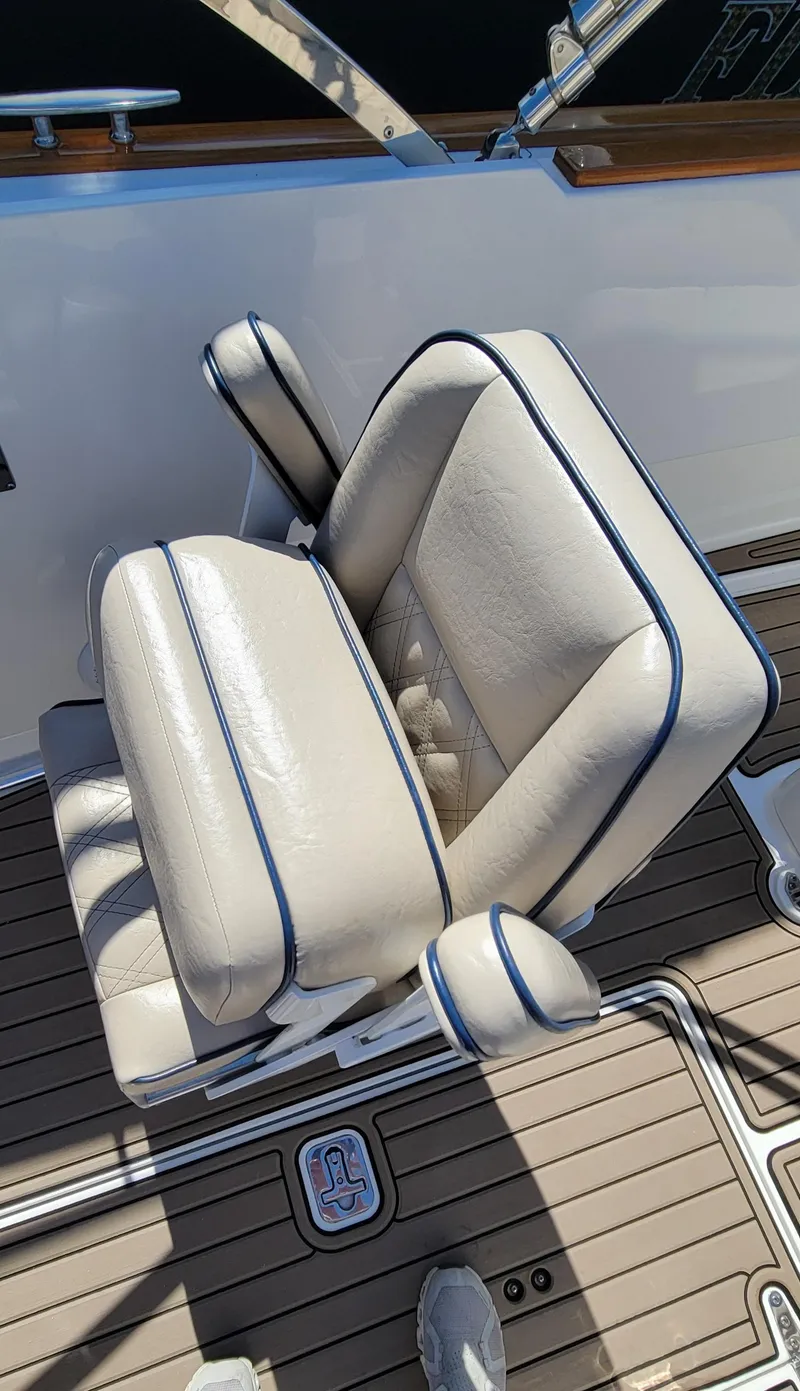Slide: The Image of 2017 Vanquish Runabout boat seat with white leather and blue trim. - 5