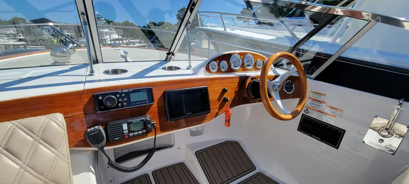 Slide: The Image of 2017 Vanquish Runabout boat dashboard with wood accents and modern controls. - 9