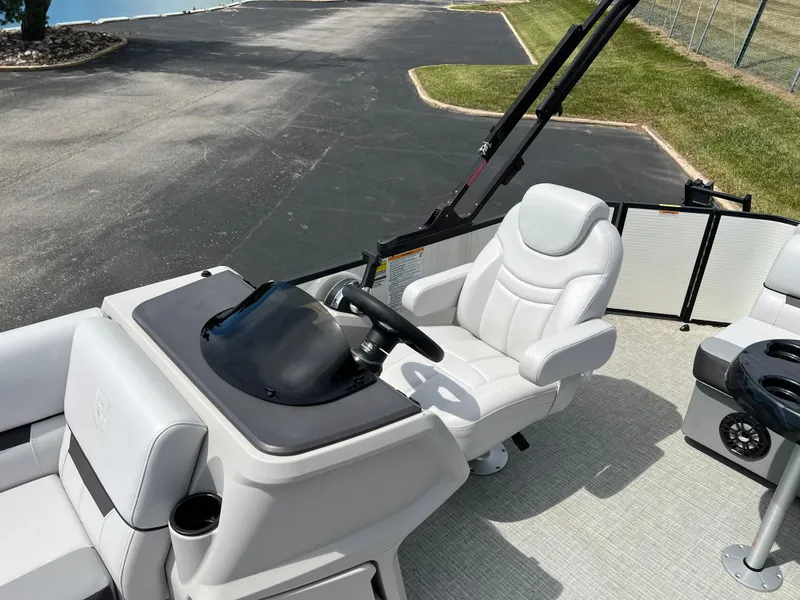 Slide: The Image of 2023 Godfrey Sweetwater 2486 C boat helm with comfortable captain's chair and steering wheel. - 12