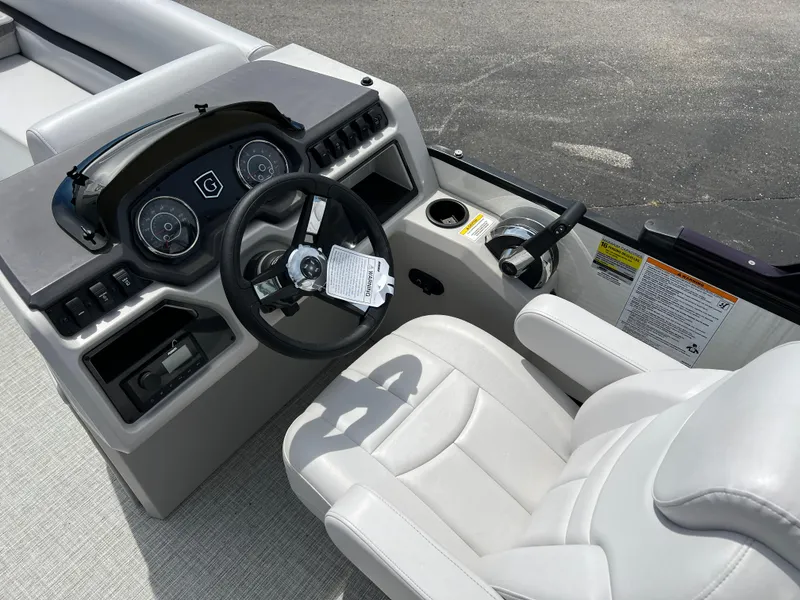 Slide: The Image of 2023 Godfrey Sweetwater 2486 C boat cockpit with steering wheel and captain's chair. - 18