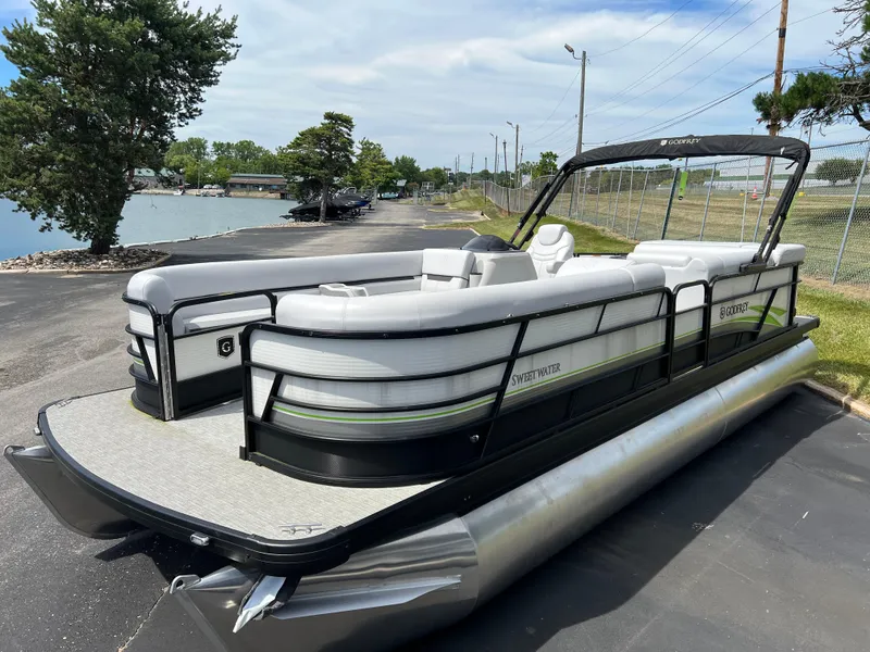 Slide: The Image of 2023 Godfrey Sweetwater 2486 C pontoon boat docked near a lake. - 3