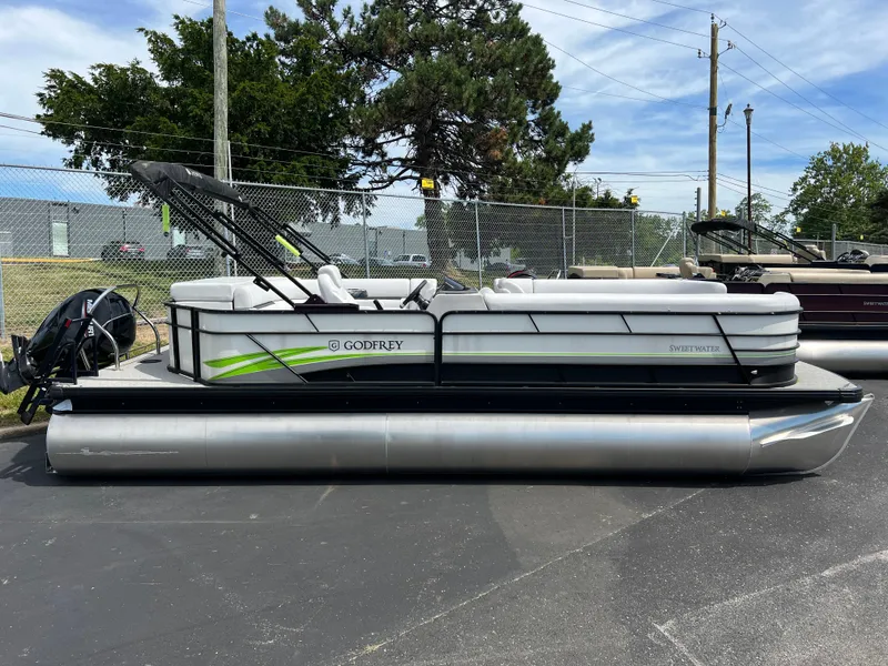 Slide: The Image of 2023 Godfrey Sweetwater 2486 C pontoon boat in a parking lot. - 5
