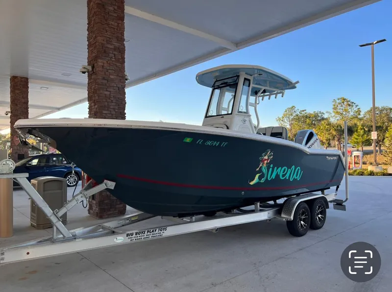 The Image of 2022 Tidewater 232 CC Adventure boat on trailer at a gas station. - 0