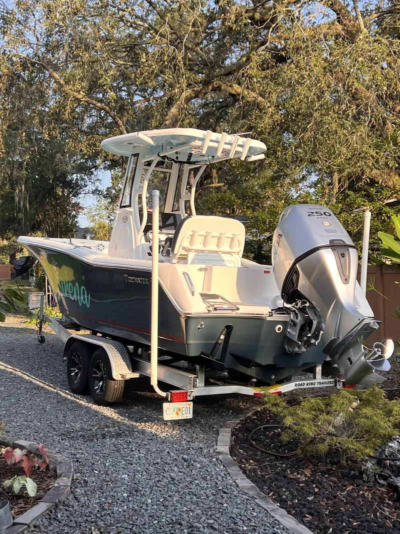 Slide: The Image of 2022 Tidewater 232 CC Adventure boat on trailer, parked outdoors. - 1