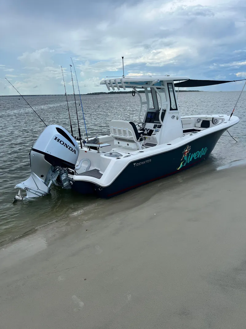 Slide: The Image of 2022 Tidewater 232 CC Adventure boat with Honda engine on sandy shore. - 2
