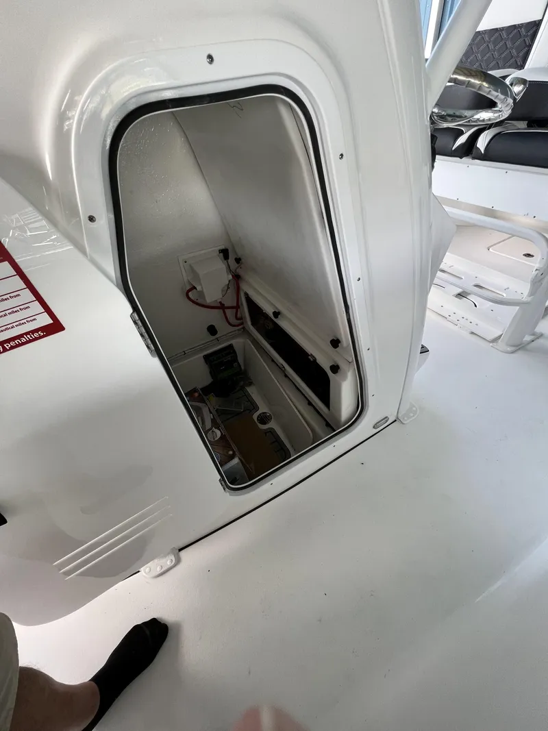 Slide: The Image of 2022 Tidewater 232 CC Adventure boat storage compartment with open hatch, showcasing interior details. - 3