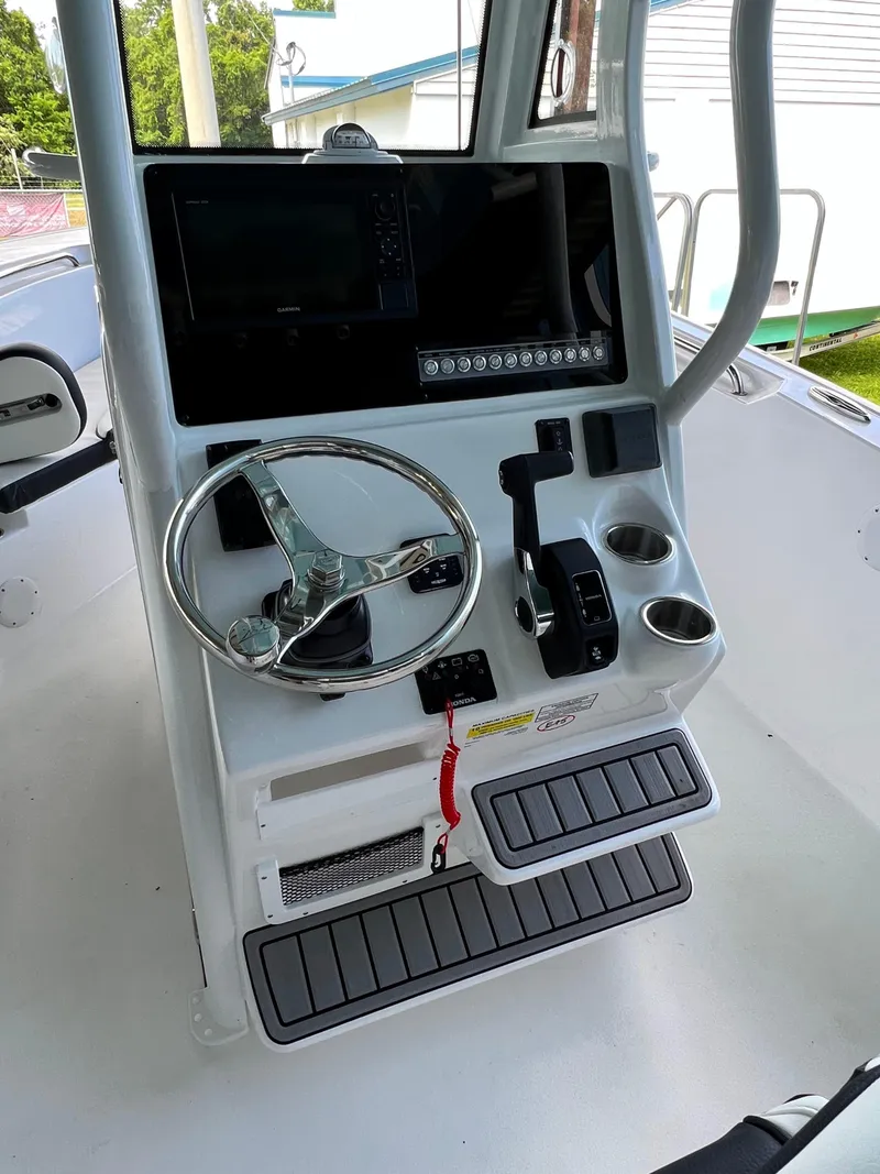 Slide: The Image of 2022 Tidewater 232 CC Adventure boat console with steering wheel and controls. - 6