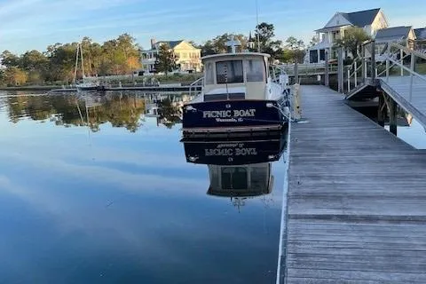 Slide: The Image of 2003 Legacy Yachts 34 Sedan docked by waterfront homes, reflecting on calm water. - 12