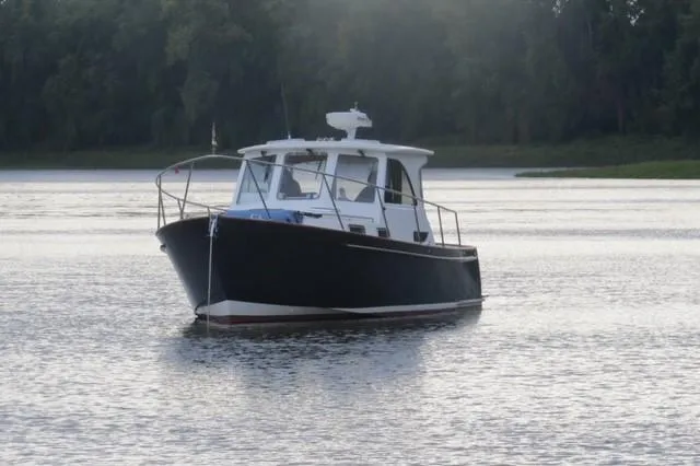 Slide: The Image of 2003 Legacy Yachts 34 Sedan on calm water, surrounded by trees. - 13