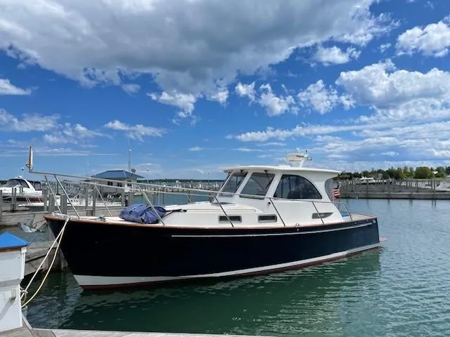 Slide: The Image of 2003 Legacy Yachts 34 Sedan docked under a partly cloudy sky. - 15