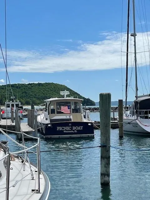 Slide: The Image of 2003 Legacy Yachts 34 Sedan docked in a scenic marina with blue skies. - 18