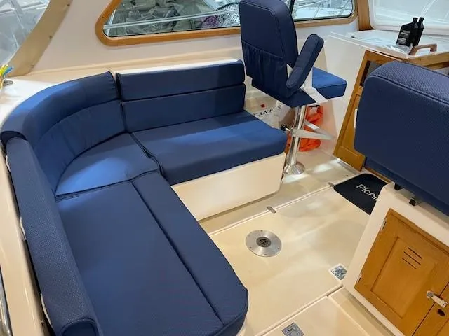 Slide: The Image of 2003 Legacy Yachts 34 Sedan interior with blue seating and wooden accents. - 28