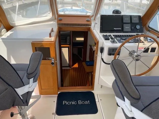 Slide: The Image of 2003 Legacy Yachts 34 Sedan interior with helm, seating, and cabin entrance. - 31