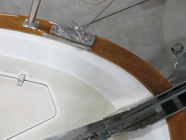 Slide: The Image of 2003 Legacy Yachts 34 Sedan deck detail with cleat and wooden trim. - 36