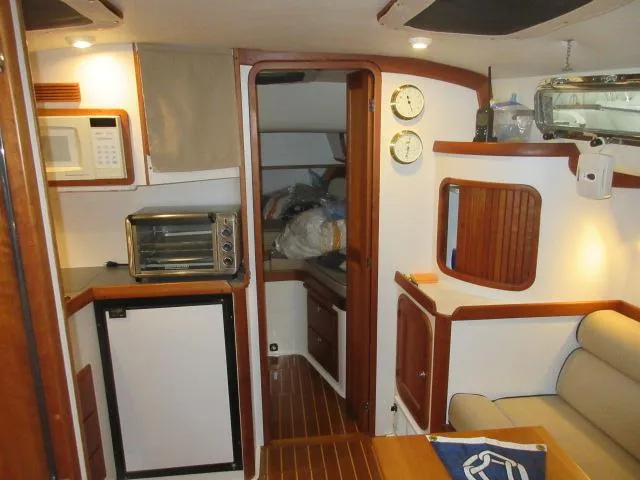 Slide: The Image of Interior of 2003 Legacy Yachts 34 Sedan with kitchenette and seating area. - 44