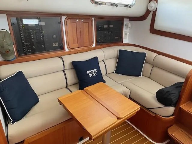 Slide: The Image of Interior of 2003 Legacy Yachts 34 Sedan with beige seating and wooden table. - 47