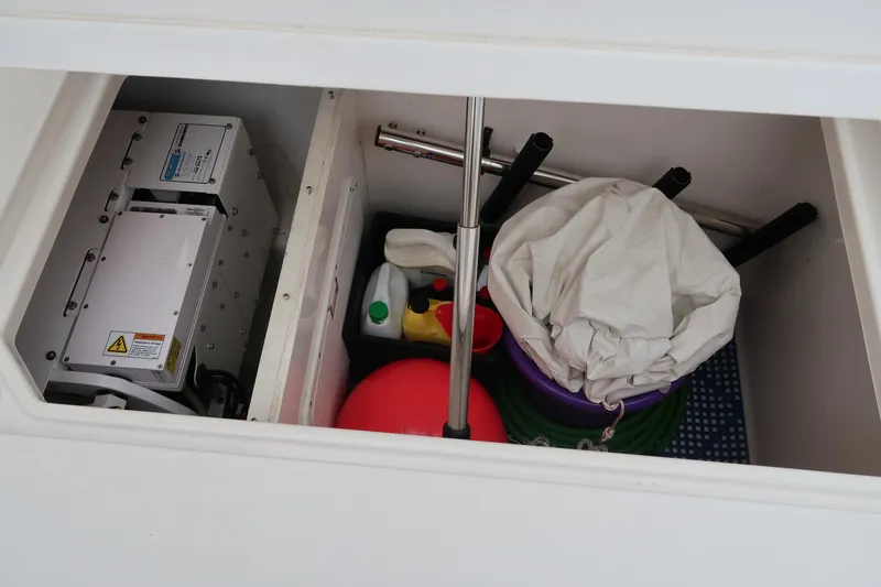 Slide: The Image of Storage compartment of a 2016 Invincible 42 Open Fisherman boat with cleaning supplies. - 23