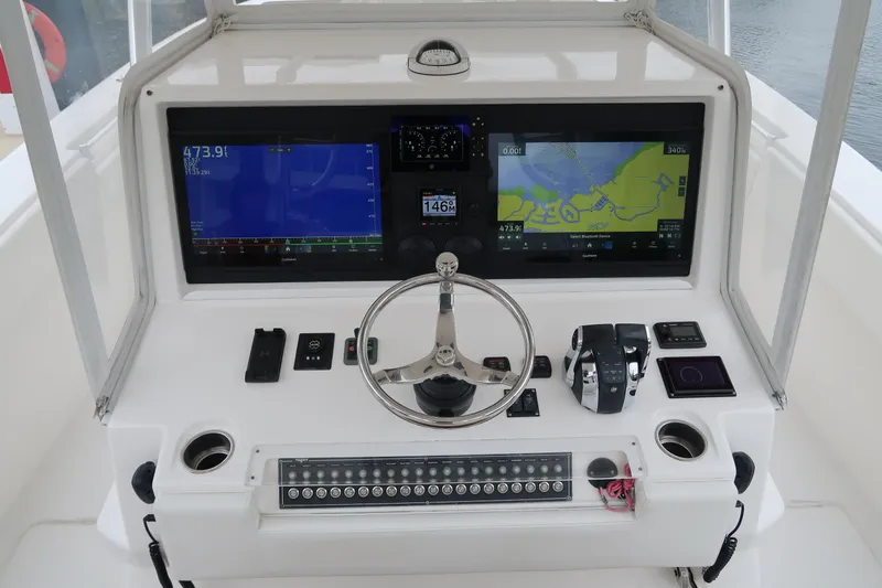 Slide: The Image of 2016 Invincible 42 Open Fisherman boat dashboard with dual navigation screens and controls. - 25