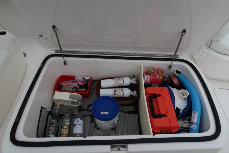 Slide: The Image of Storage compartment of a 2016 Invincible 42 Open Fisherman boat with various supplies. - 44