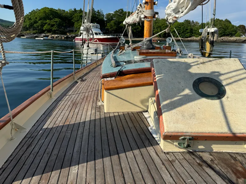 Slide: The Image of Wooden deck of 1996 Custom John Alden Malabar II sailboat, docked in serene waters. - 15