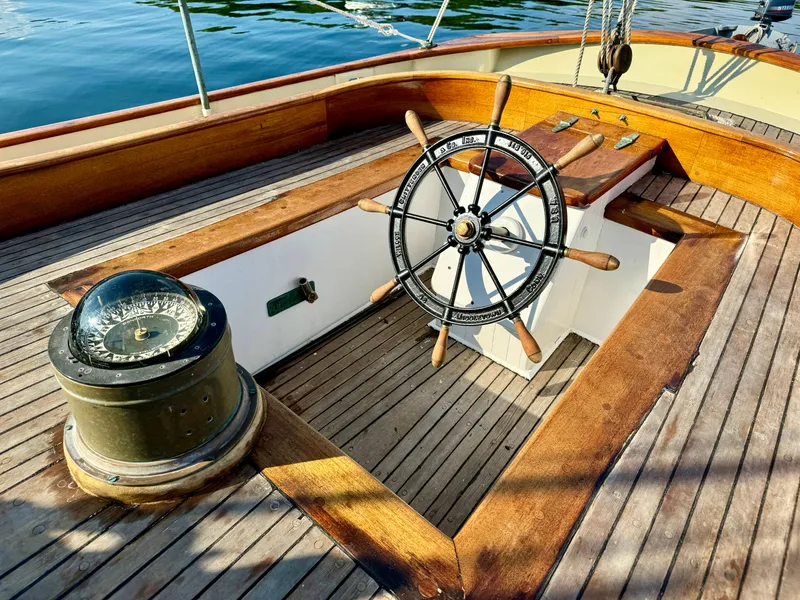 Slide: The Image of Wooden deck of 1996 Custom John Alden Malabar II sailboat with steering wheel and compass. - 18