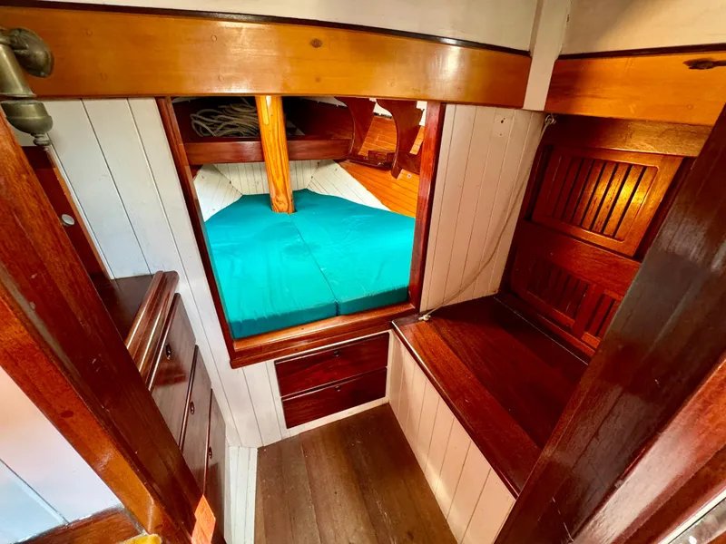 Slide: The Image of Cozy cabin interior of 1996 Custom John Alden Malabar II with wooden furnishings and teal bedding. - 31