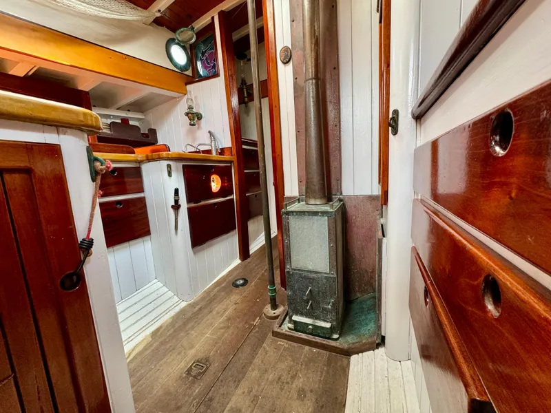 Slide: The Image of Interior of 1996 Custom John Alden Malabar II sailboat with wood paneling and stove. - 39