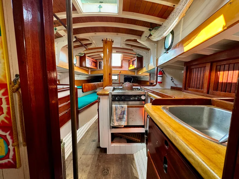 Slide: The Image of Interior of 1996 Custom John Alden Malabar II sailboat with wooden finishes and compact kitchen. - 40