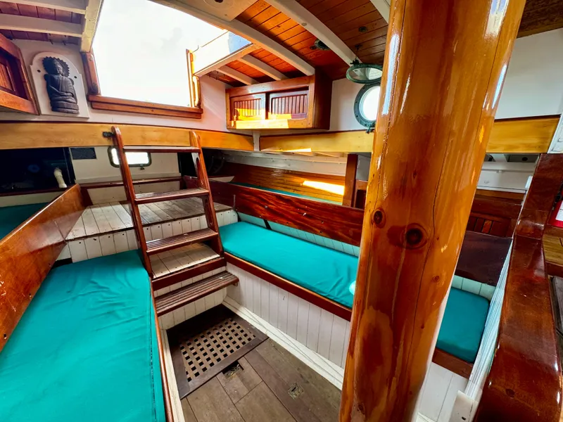 Slide: The Image of Interior of 1996 Custom John Alden Malabar II sailboat with wooden finishes and teal cushions. - 42