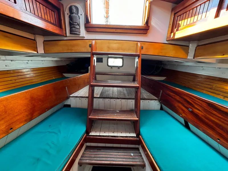 Slide: The Image of Interior of 1996 Custom John Alden Malabar II sailboat with wooden finishes and teal cushions. - 44