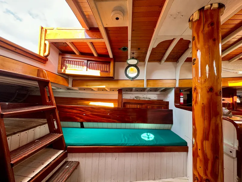 Slide: The Image of Interior of 1996 Custom John Alden Malabar II sailboat with wooden finishes and green seating. - 46
