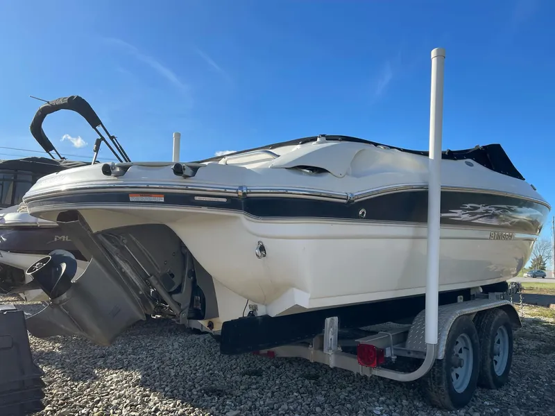 Slide: The Image of 2012 Stingray 225 LR boat on trailer, parked on gravel, under clear blue sky. - 13