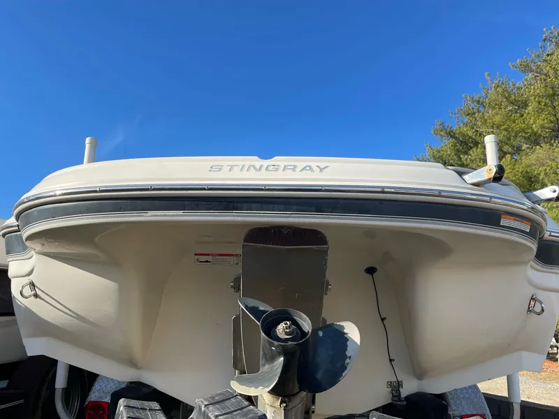 Slide: The Image of 2012 Stingray 225 LR boat stern view with propeller, under clear blue sky. - 3