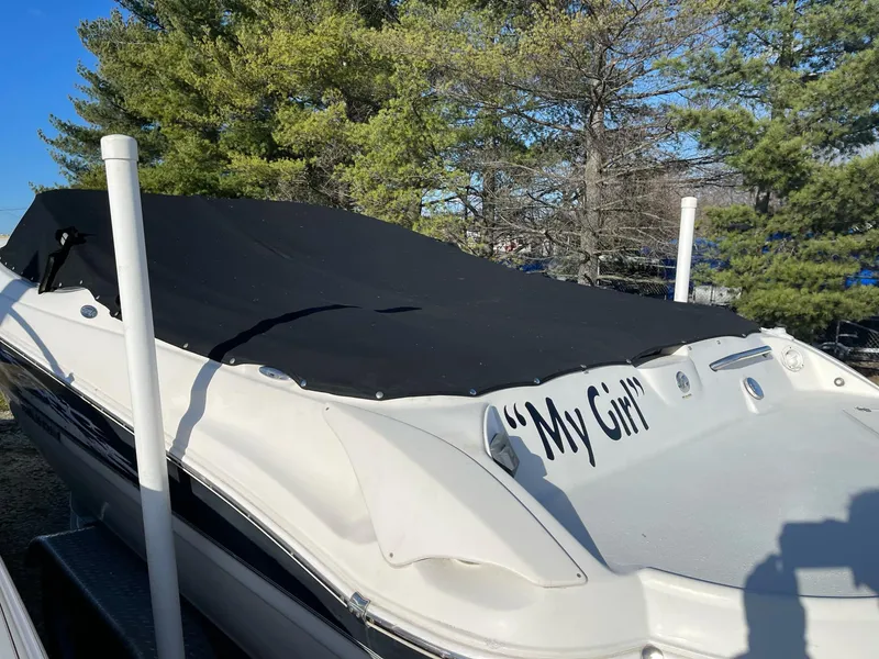 Slide: The Image of 2012 Stingray 225 LR boat named "My Girl" with black cover, surrounded by trees. - 4