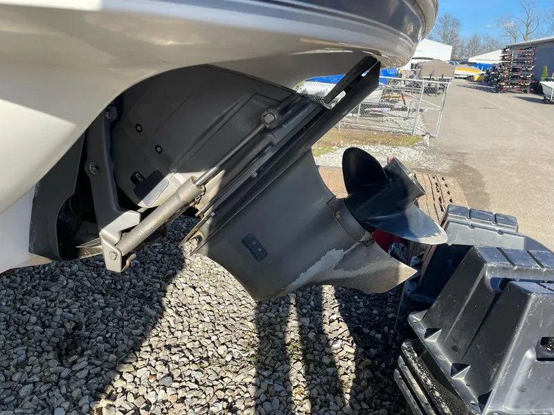 Slide: The Image of 2012 Stingray 225 LR boat outdrive on gravel, showcasing propeller and stern. - 5