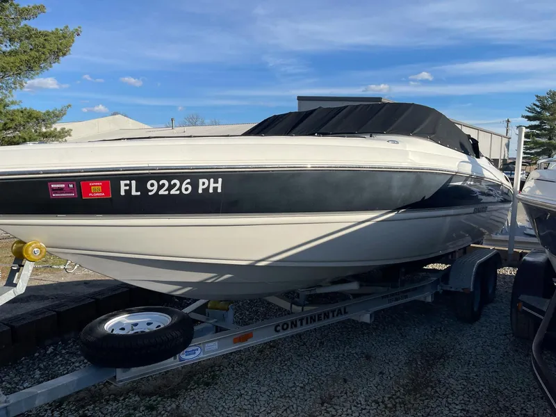 Slide: The Image of 2012 Stingray 225 LR boat on trailer, registration FL 9226 PH, parked outdoors. - 9