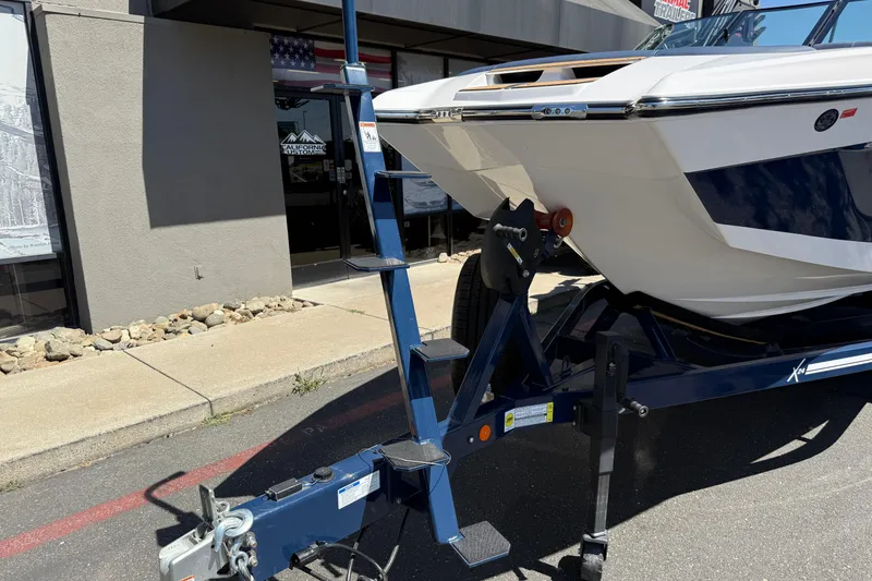 Slide: The Image of 2024 MasterCraft X24 boat on trailer outside dealership, showcasing sleek design and modern features. - 13