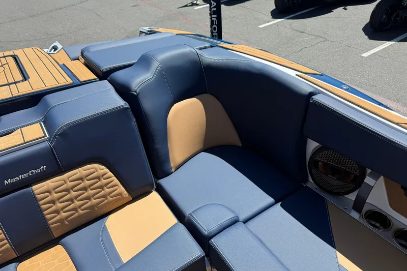 Slide: The Image of 2024 MasterCraft X24 boat interior with blue and tan seating, featuring premium stitching. - 21