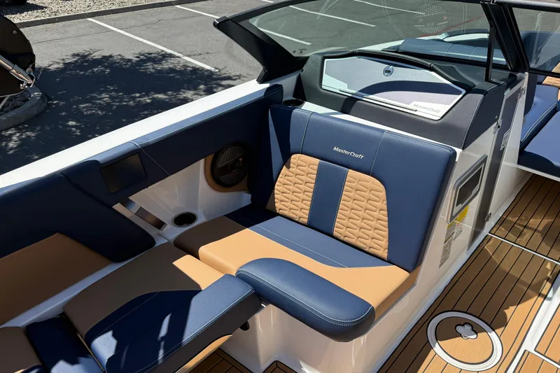 Slide: The Image of 2024 MasterCraft X24 boat interior with blue and tan seating, featuring modern design and detailing. - 24
