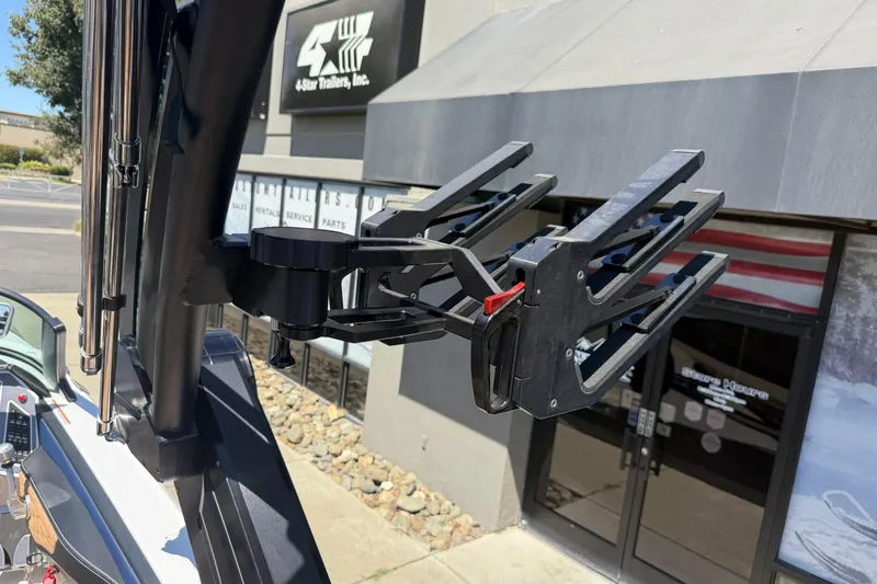 Slide: The Image of 2024 MasterCraft X24 boat with a wakeboard rack, parked outside a trailer store. - 31
