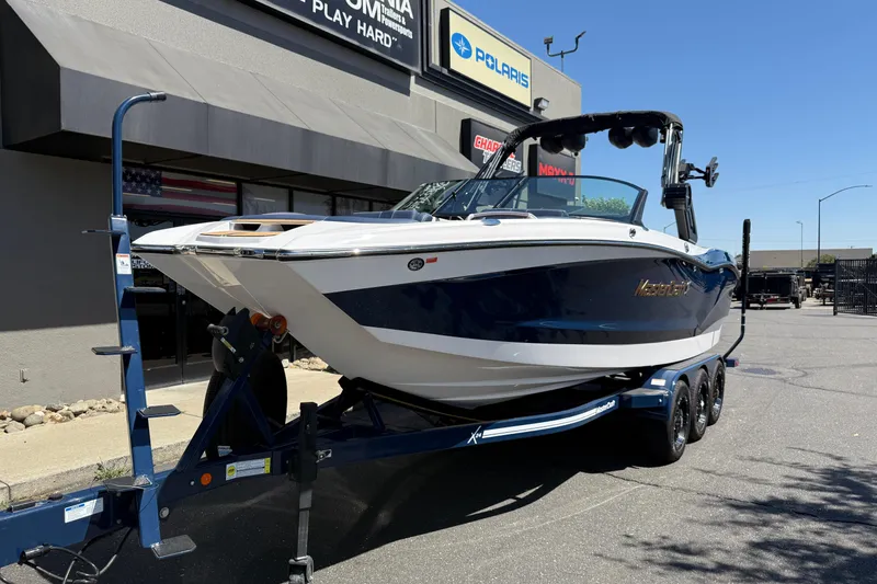 Slide: The Image of 2024 MasterCraft X24 boat on trailer outside dealership, showcasing sleek design and modern features. - 8