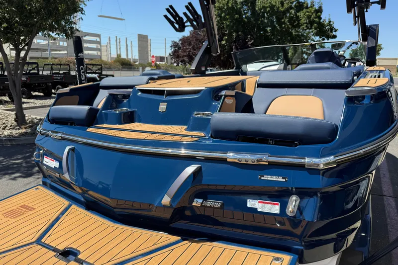 Slide: The Image of 2024 MasterCraft X24 boat with blue and tan interior, docked outdoors. - 9